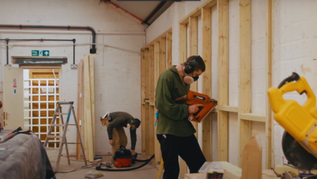 Two men working on improving an office space with match funding.