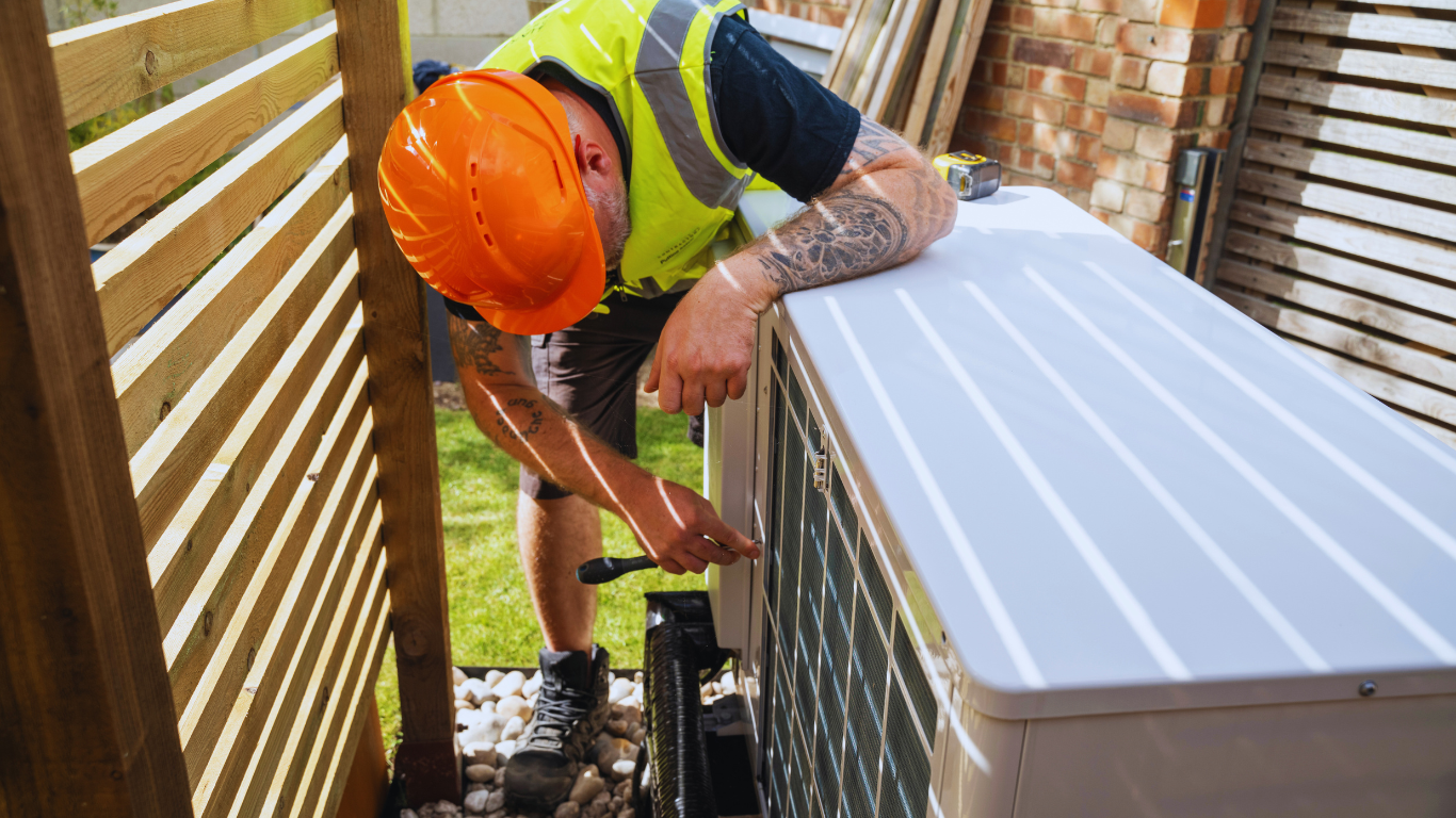 A man fits a heat pump for a business using match funding.