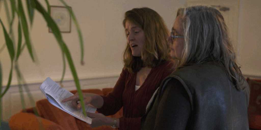 An assessor and client talk through an energy assessment report.