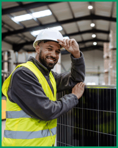 A man holding a solar panel in a warehouse, ready to install as part of match funding.