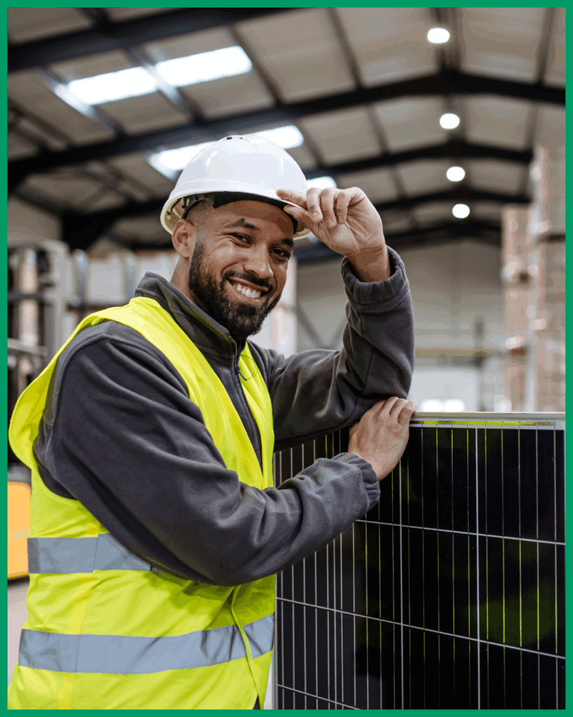 A man holding a solar panel in a warehouse, ready to install as part of match funding.