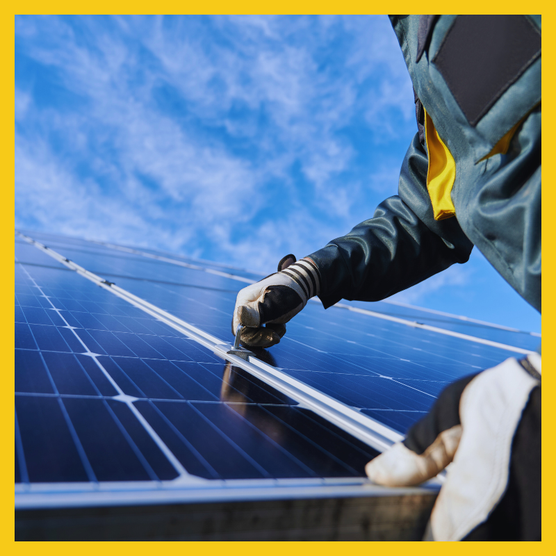 A close up of a man installing solar panels on a rooftop.